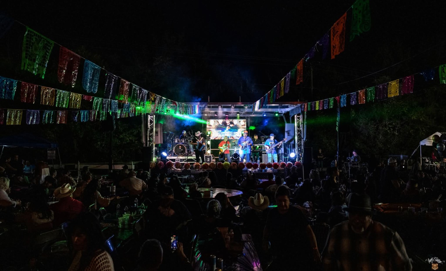 Large nighttime festival production with stage lighting and audience