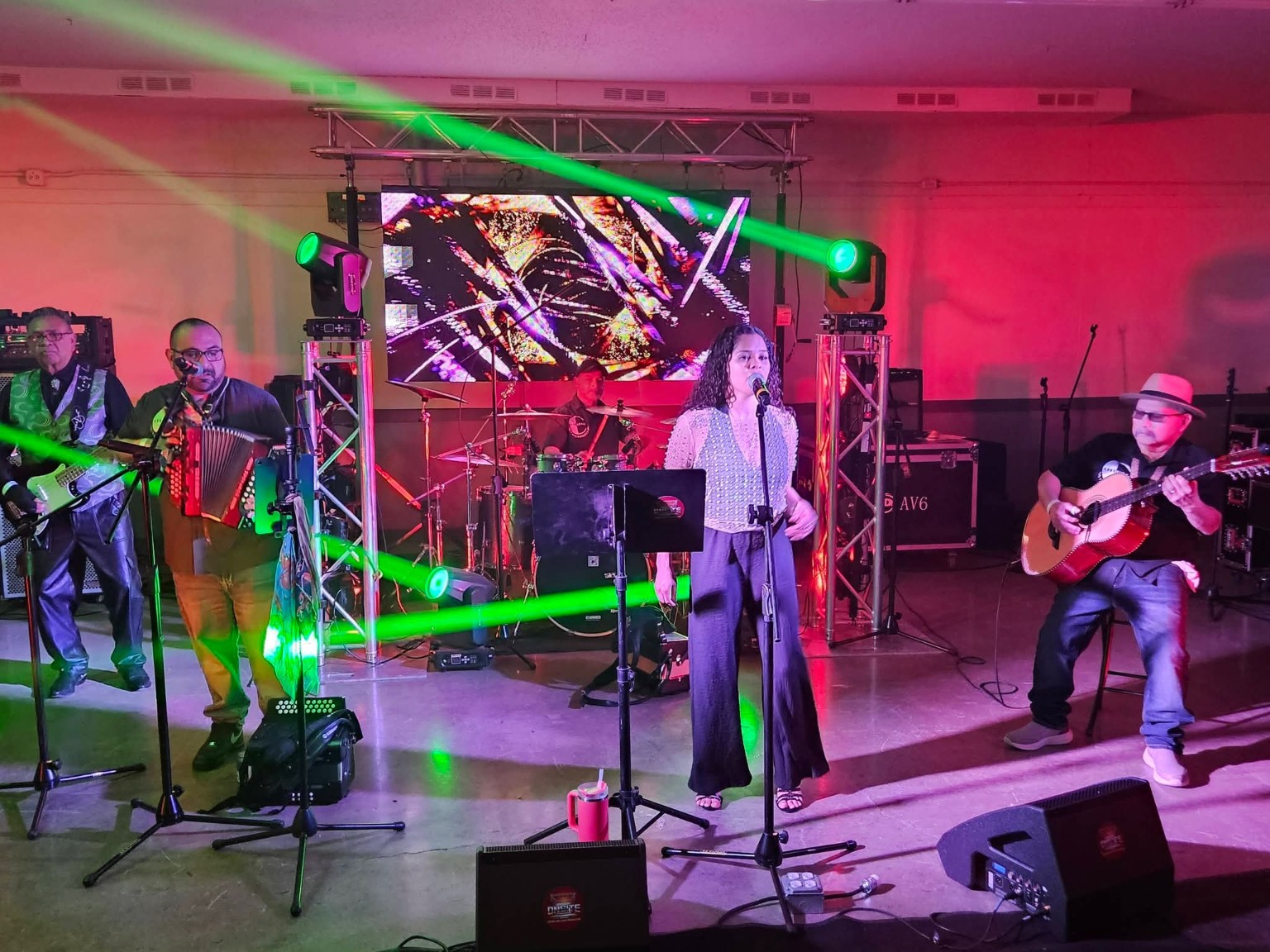 Live band performing under coordinated green stage lighting
